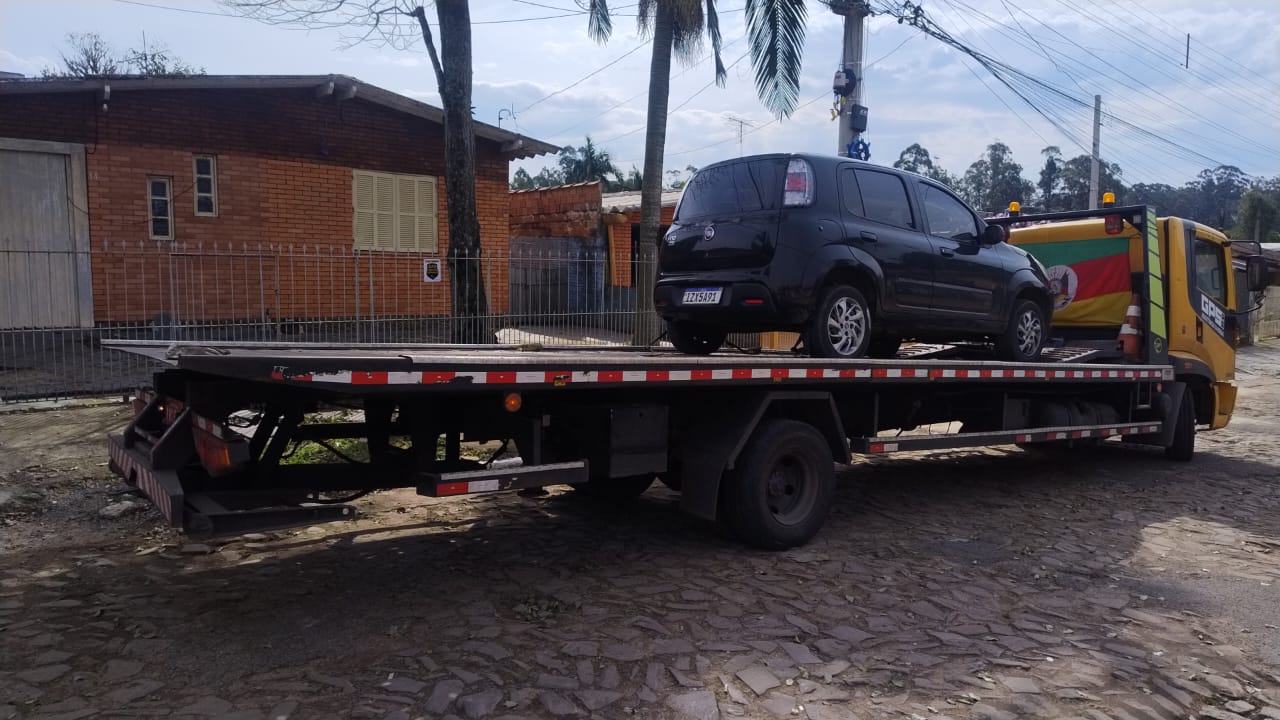 Fiat Uno preto sendo transportado por guincho